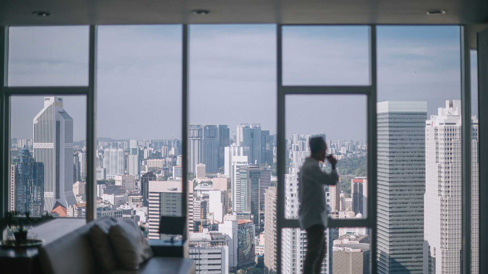 man in high building overlooking asian city