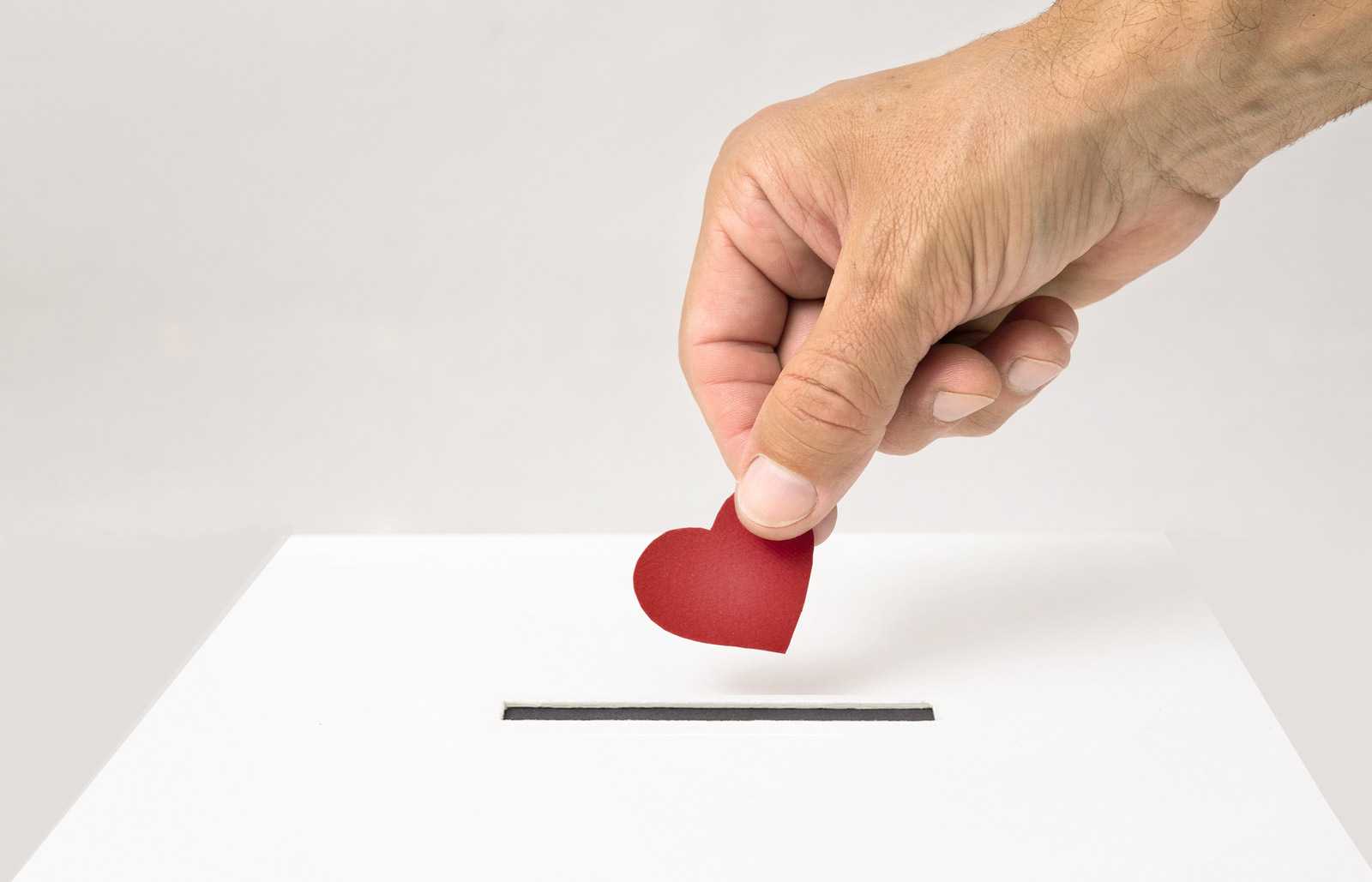 hand placing red heart in ballot box