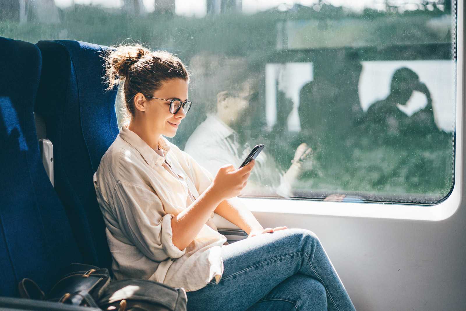 woman using phone while on train