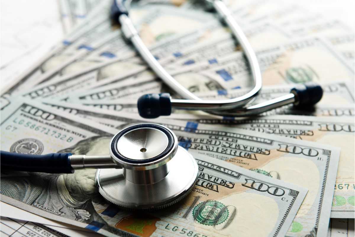 Stethoscope on top of hundred dollar bills