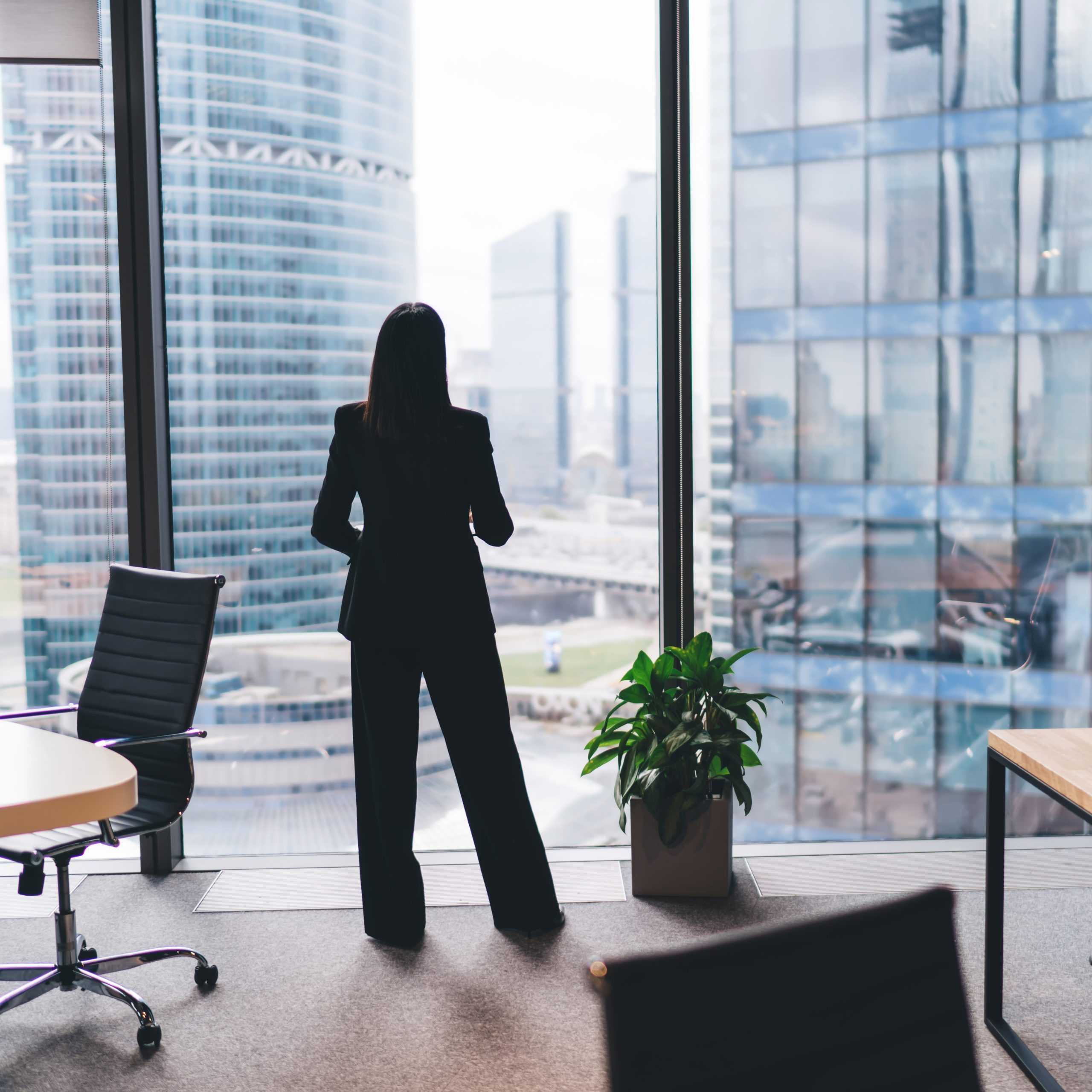 Businesswoman looking out high rise window