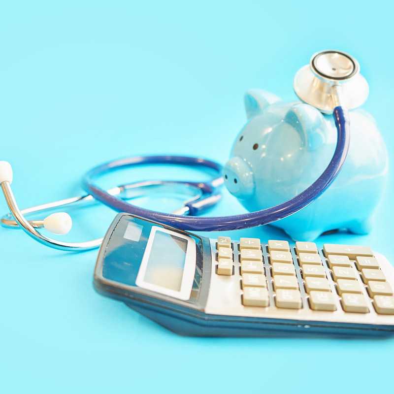 Piggy bank with stethoscope isolated on blue background