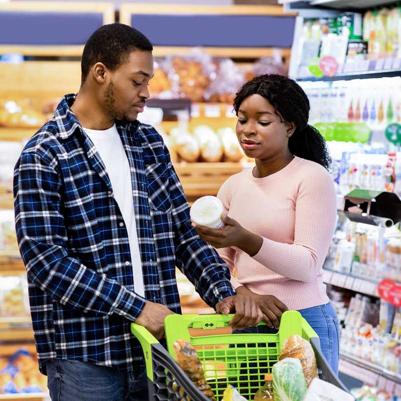 Couple in grocery story deciding on yogurt